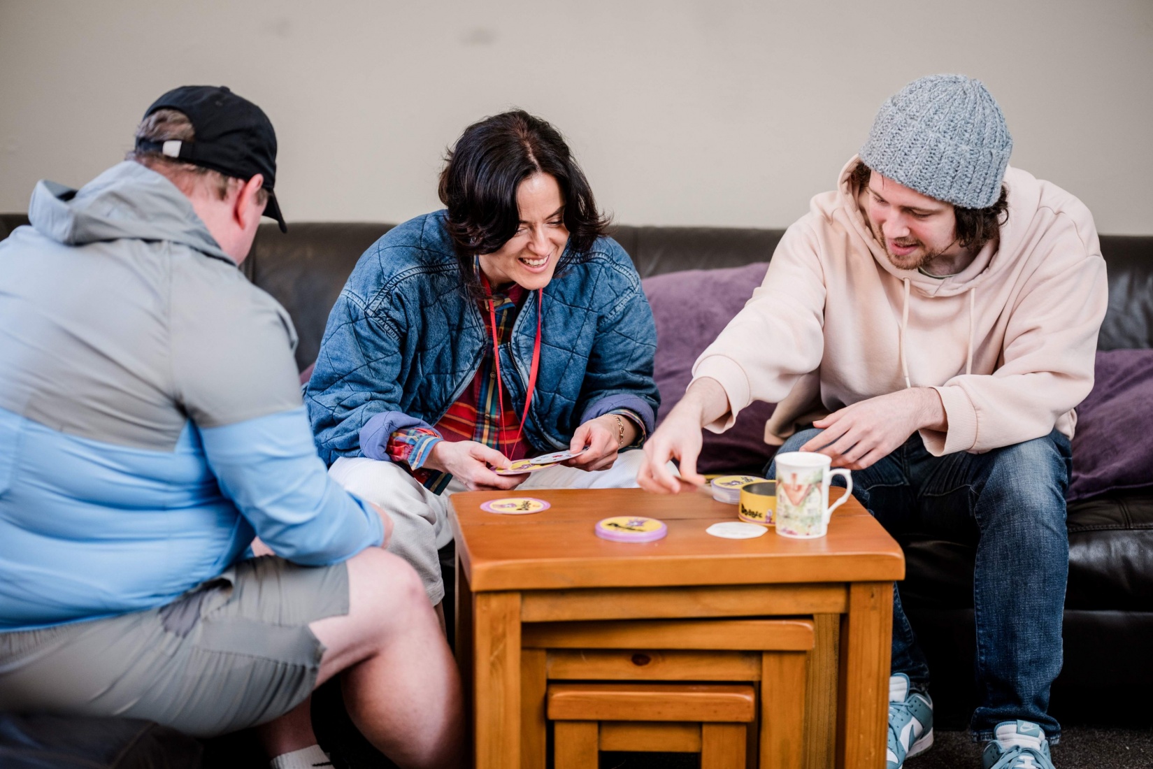 Katie and 2 members sat on a sofa around a coffee table