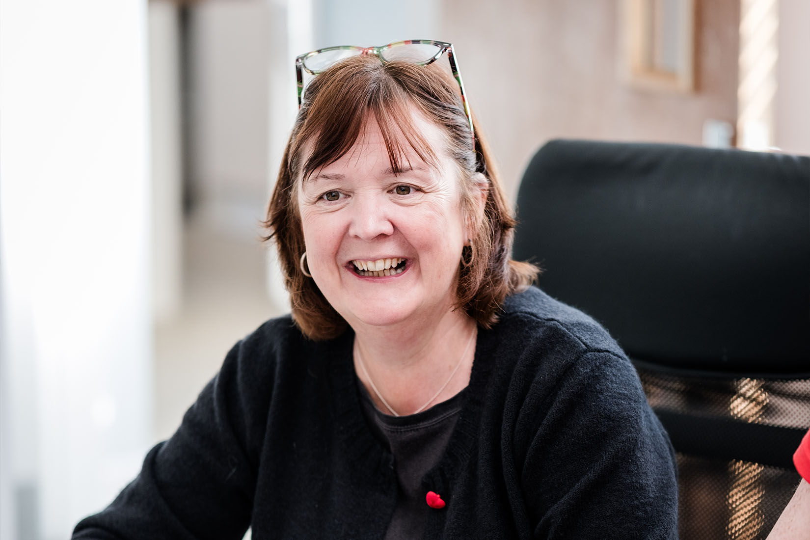 A lady seated on a chair engaged in a conversation